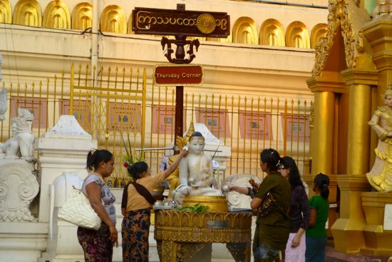 Pengunjung melakukan ritual memandikan patung sambil berdoa